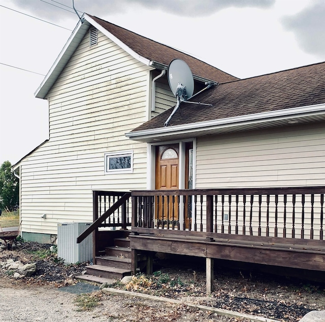 rear view of property with a wooden deck and central AC unit