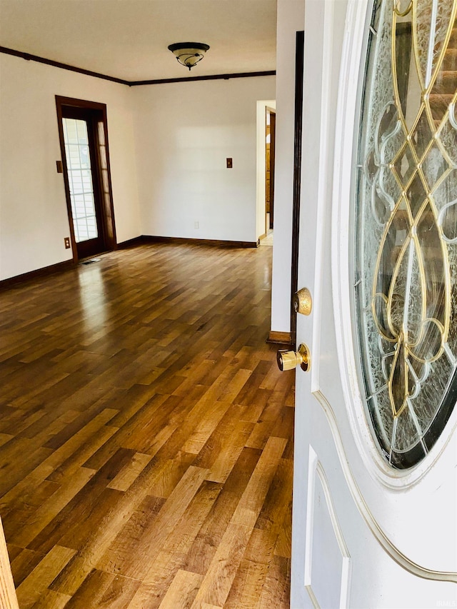 unfurnished room featuring ornamental molding and dark hardwood / wood-style flooring