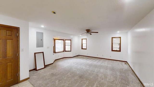 empty room with light carpet, electric panel, and ceiling fan