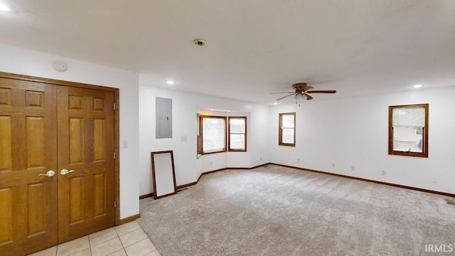 unfurnished room with ceiling fan, light colored carpet, and electric panel