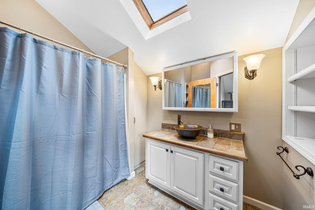 bathroom with vanity, tile patterned flooring, lofted ceiling with skylight, and curtained shower