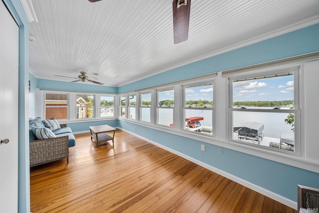 sunroom featuring ceiling fan, a water view, and a healthy amount of sunlight