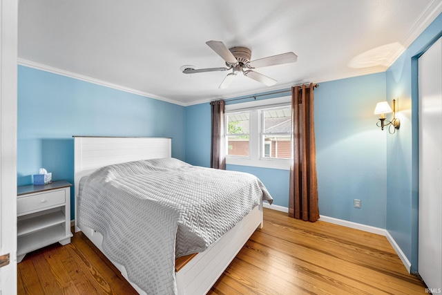 bedroom with crown molding, hardwood / wood-style floors, and ceiling fan