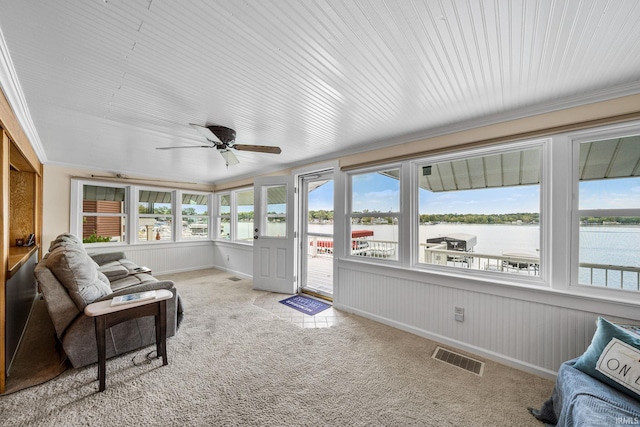 sunroom / solarium featuring a water view and ceiling fan