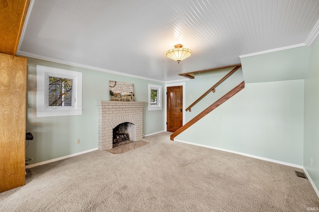 unfurnished living room with a brick fireplace, carpet floors, and crown molding