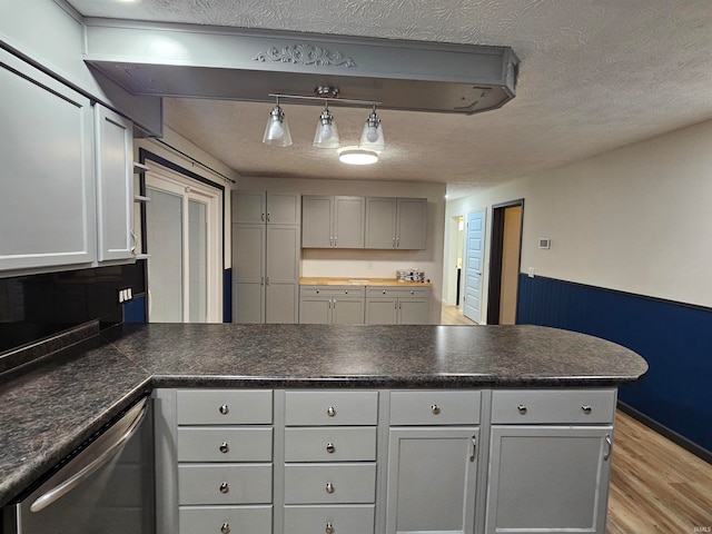 kitchen featuring hanging light fixtures, gray cabinetry, a textured ceiling, light hardwood / wood-style flooring, and dishwasher