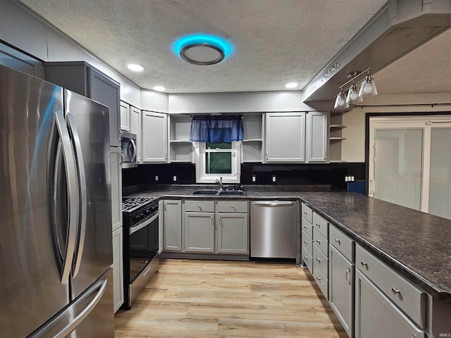 kitchen with gray cabinetry, stainless steel appliances, a textured ceiling, light hardwood / wood-style flooring, and sink