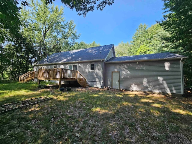 rear view of house featuring a deck and a yard