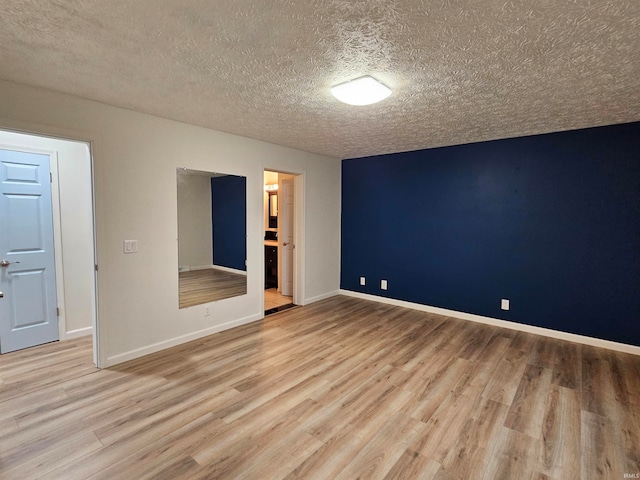 spare room with light hardwood / wood-style flooring and a textured ceiling