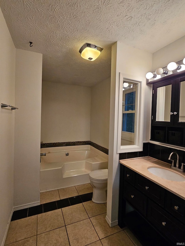 bathroom with vanity, toilet, a textured ceiling, a bathing tub, and tile patterned flooring