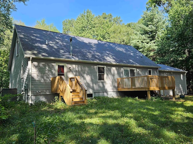 back of house featuring a deck and a yard