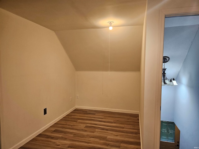 bonus room with lofted ceiling and dark wood-type flooring