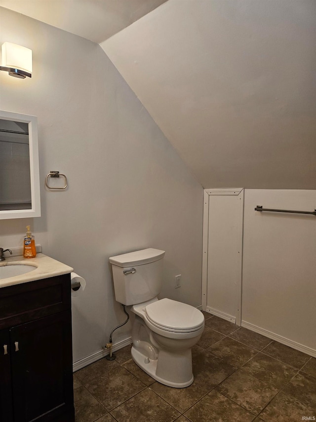 bathroom with lofted ceiling, vanity, and toilet