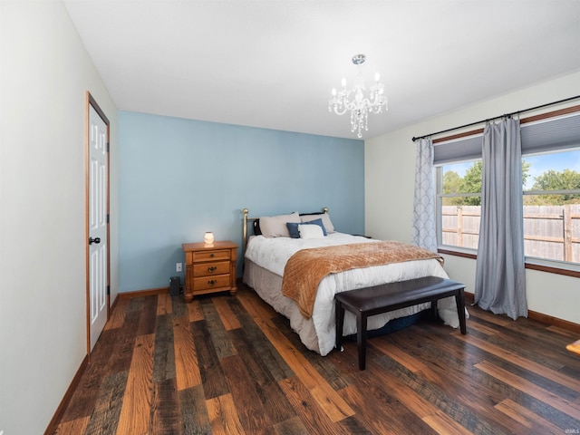 bedroom featuring an inviting chandelier and dark wood-type flooring