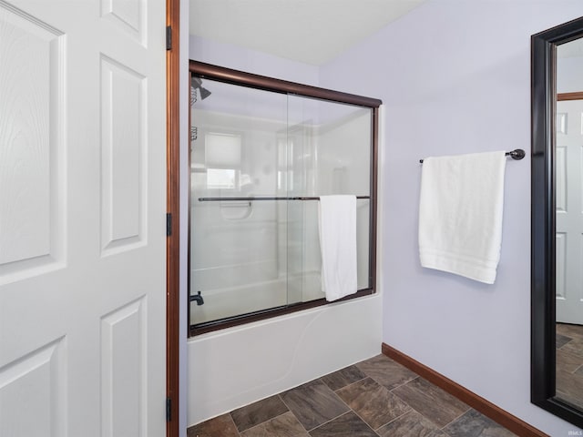 bathroom featuring bath / shower combo with glass door