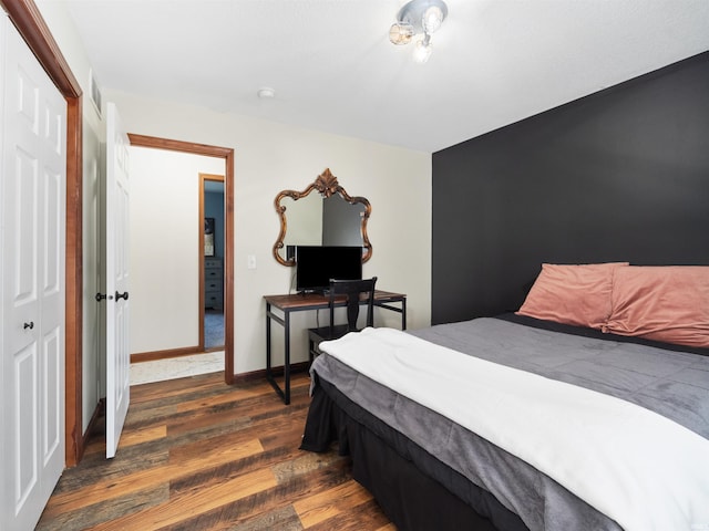 bedroom with dark hardwood / wood-style floors and a closet