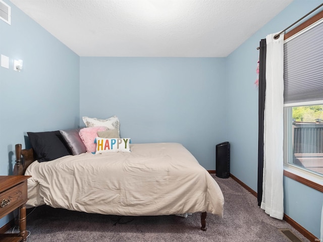 bedroom featuring carpet and a textured ceiling