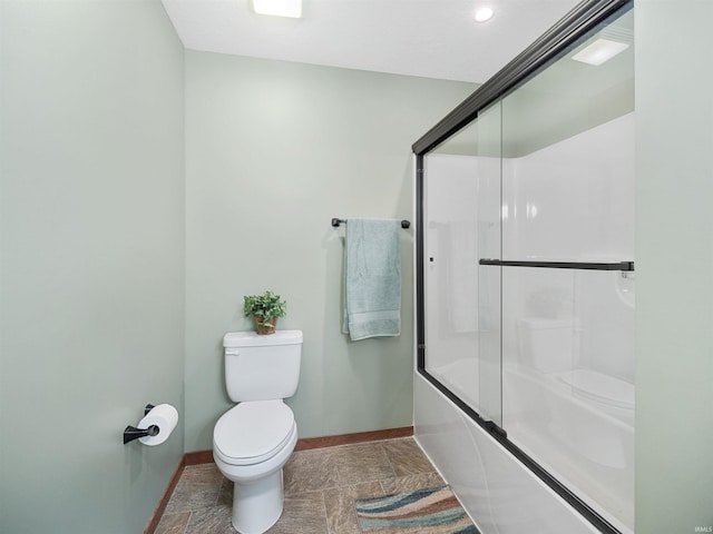 bathroom with enclosed tub / shower combo and toilet