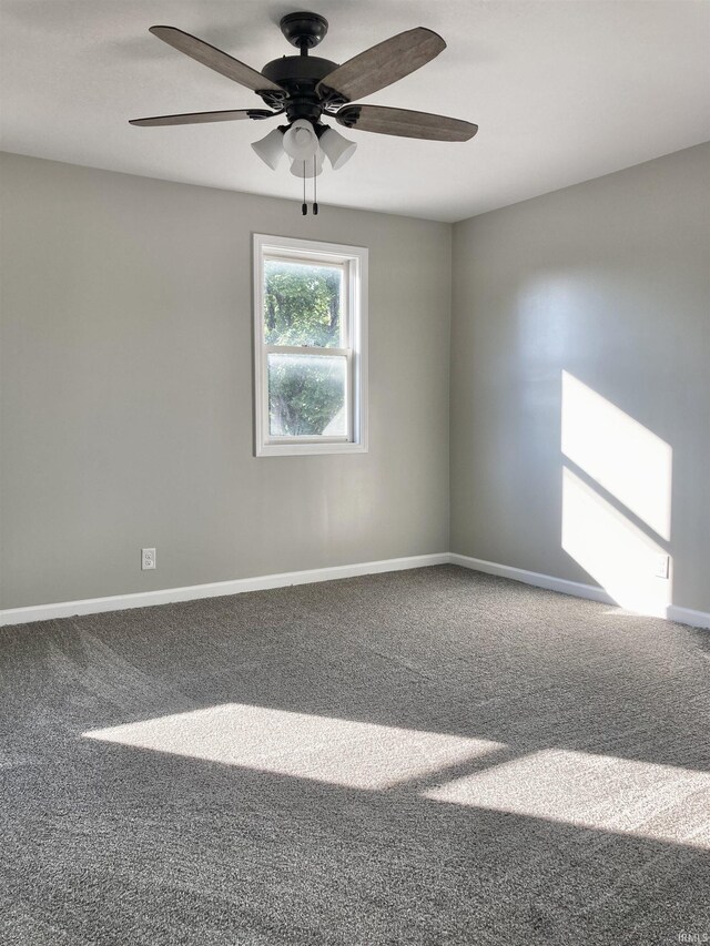 carpeted spare room featuring ceiling fan