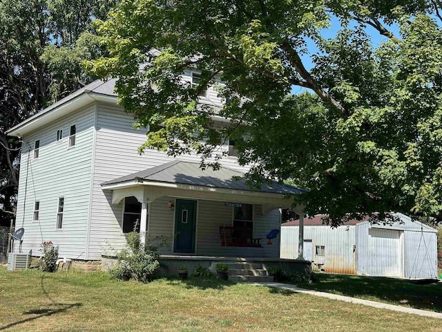 view of front facade with a storage shed, a front lawn, and covered porch