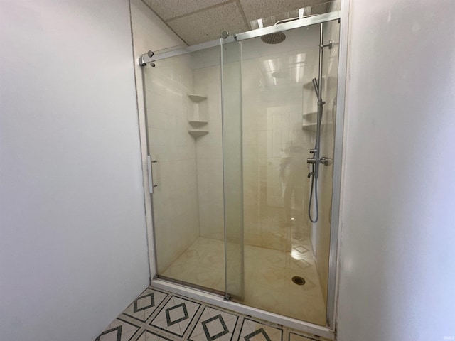 bathroom with walk in shower and a paneled ceiling