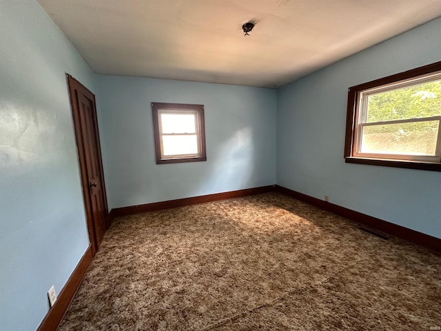 spare room featuring a healthy amount of sunlight and carpet flooring