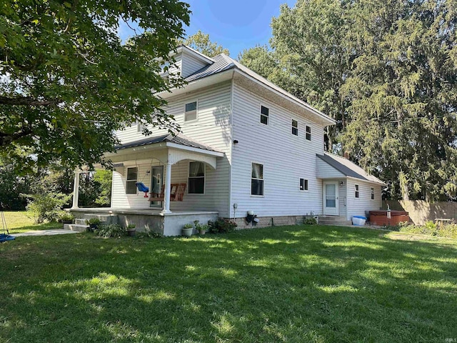 back of house with a porch and a yard