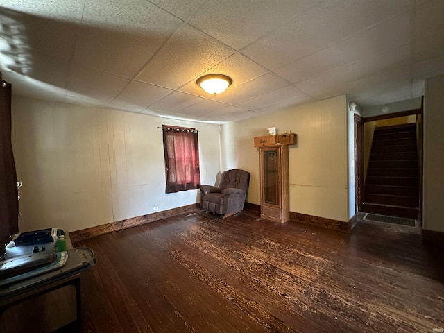 unfurnished room featuring a drop ceiling and dark wood-type flooring