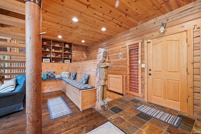 entryway featuring wood ceiling, wooden walls, dark hardwood / wood-style flooring, and a wood stove