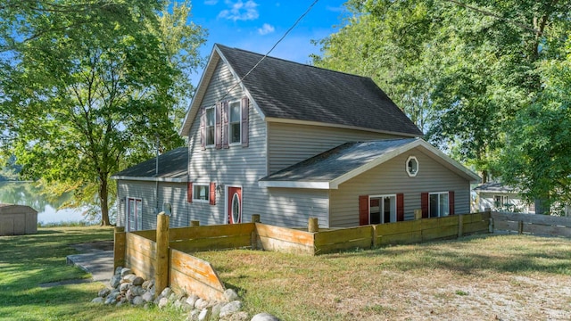 view of front of property with a front yard and a storage shed