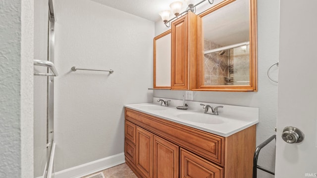 bathroom with tile patterned floors, a shower with door, and vanity