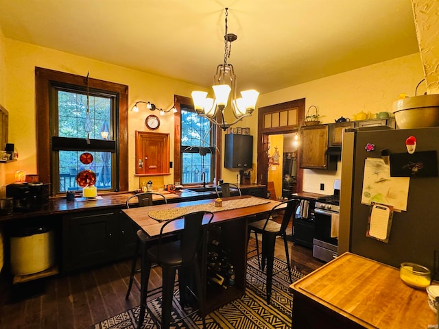 dining room with dark hardwood / wood-style flooring, sink, and a notable chandelier