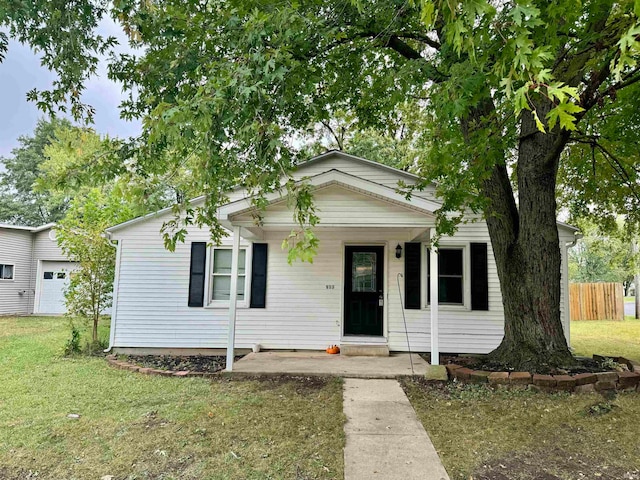 view of front facade featuring a front lawn, a porch, and a garage