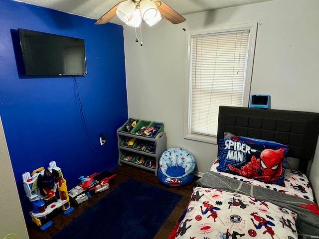 bedroom featuring ceiling fan, dark wood-type flooring, and a textured ceiling