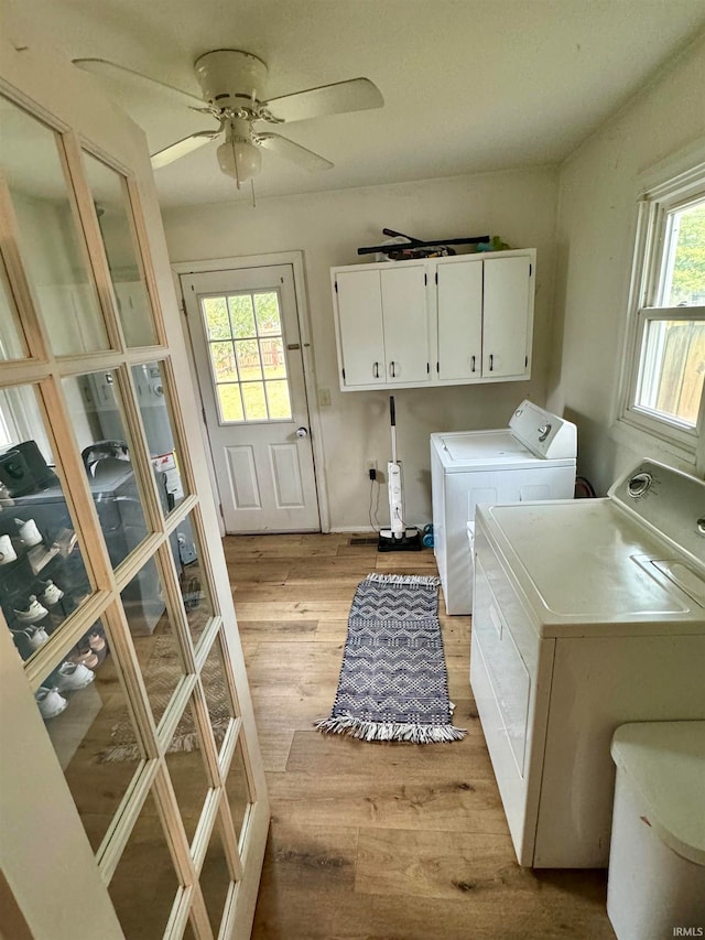 washroom featuring ceiling fan, separate washer and dryer, cabinets, and a healthy amount of sunlight