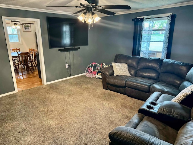 living room featuring a textured ceiling, ceiling fan, carpet floors, and crown molding