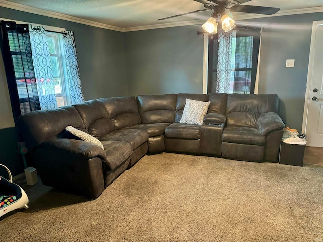 carpeted living room with ornamental molding and ceiling fan