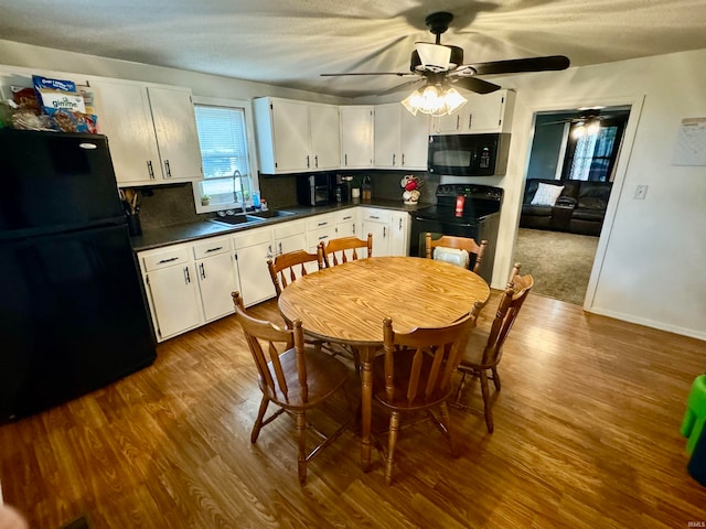 kitchen with hardwood / wood-style flooring, white cabinets, black appliances, backsplash, and ceiling fan