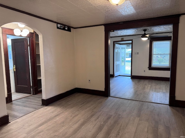 spare room featuring ceiling fan, hardwood / wood-style flooring, and crown molding