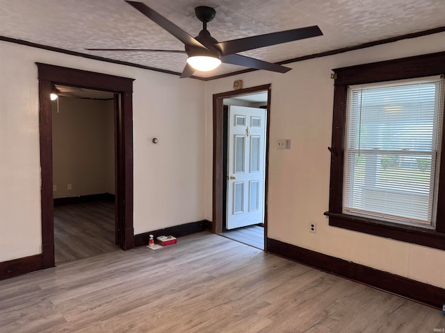 unfurnished room featuring light hardwood / wood-style floors, ceiling fan, crown molding, and a textured ceiling