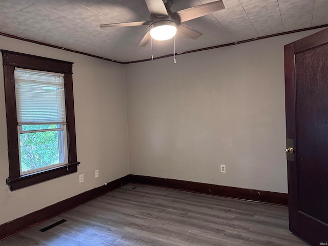 unfurnished room featuring ceiling fan, light wood-type flooring, and ornamental molding