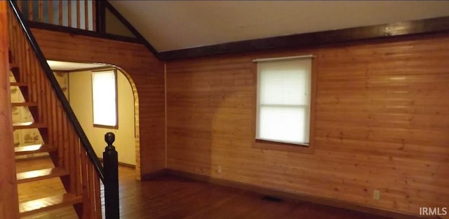 staircase with wood-type flooring and wood walls