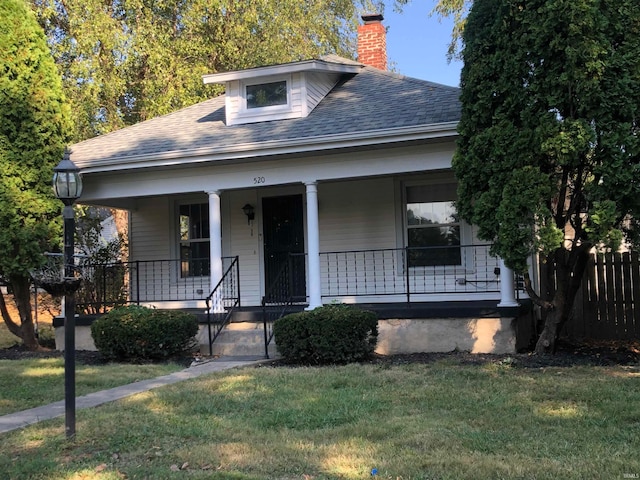 bungalow with a front lawn and covered porch