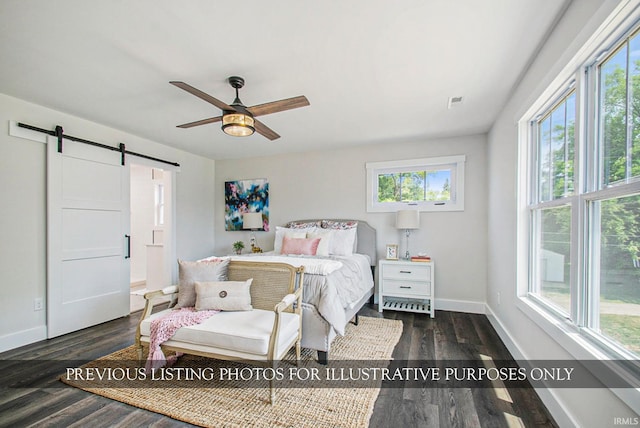 bedroom featuring ceiling fan, a barn door, and dark hardwood / wood-style flooring