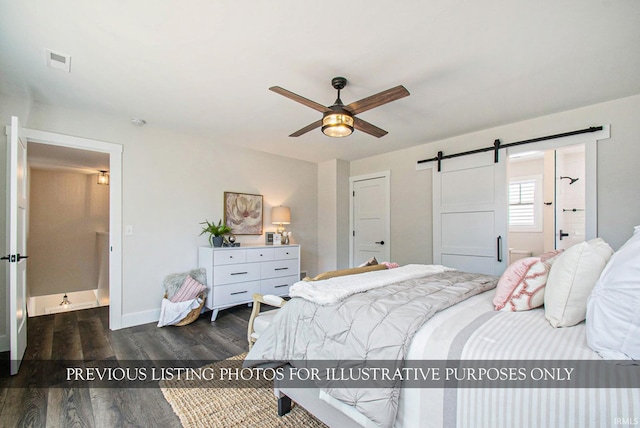 bedroom with ensuite bath, ceiling fan, dark hardwood / wood-style floors, and a barn door