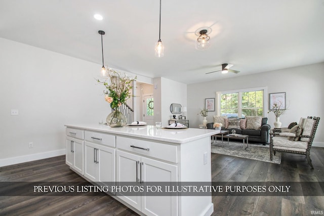 kitchen with ceiling fan, white cabinets, hanging light fixtures, and dark wood-type flooring