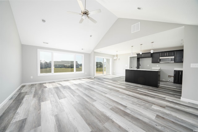 unfurnished living room featuring high vaulted ceiling, ceiling fan, and hardwood / wood-style flooring