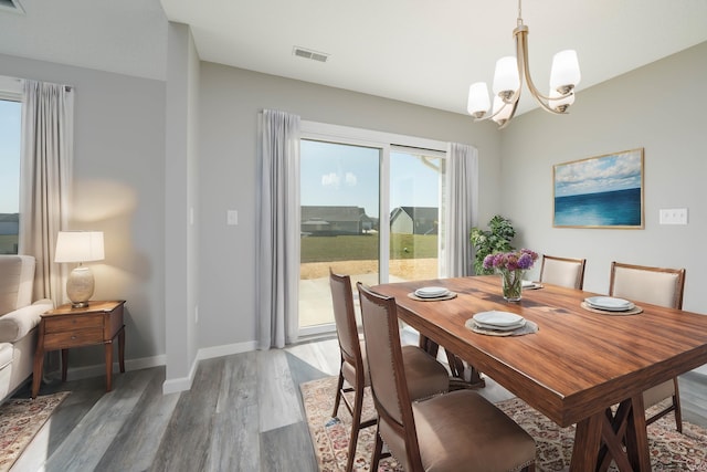 dining area with a chandelier and dark hardwood / wood-style flooring