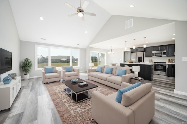 living room with light hardwood / wood-style floors, ceiling fan, high vaulted ceiling, and a wealth of natural light