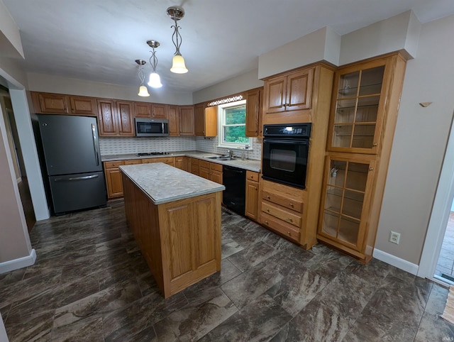 kitchen featuring hanging light fixtures, backsplash, a kitchen island, black appliances, and sink